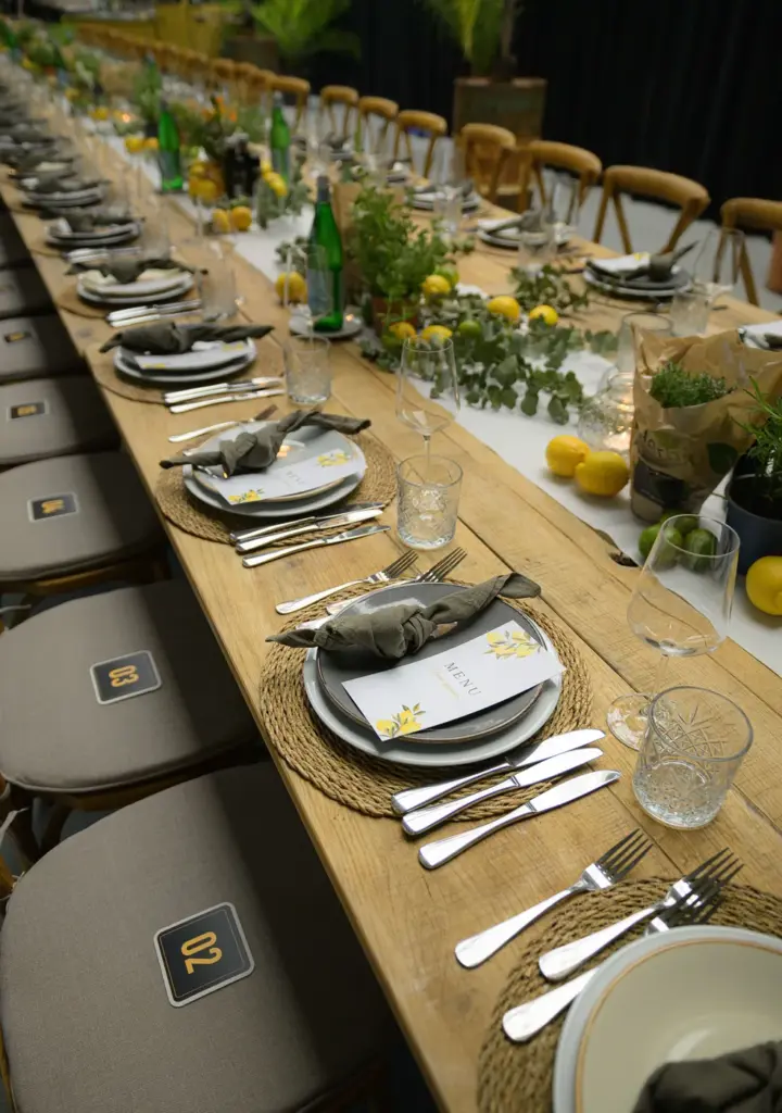 Lange gedekte dinertafel met mediterrane styling, citroenen en verse kruiden voor Brouwers Reklame