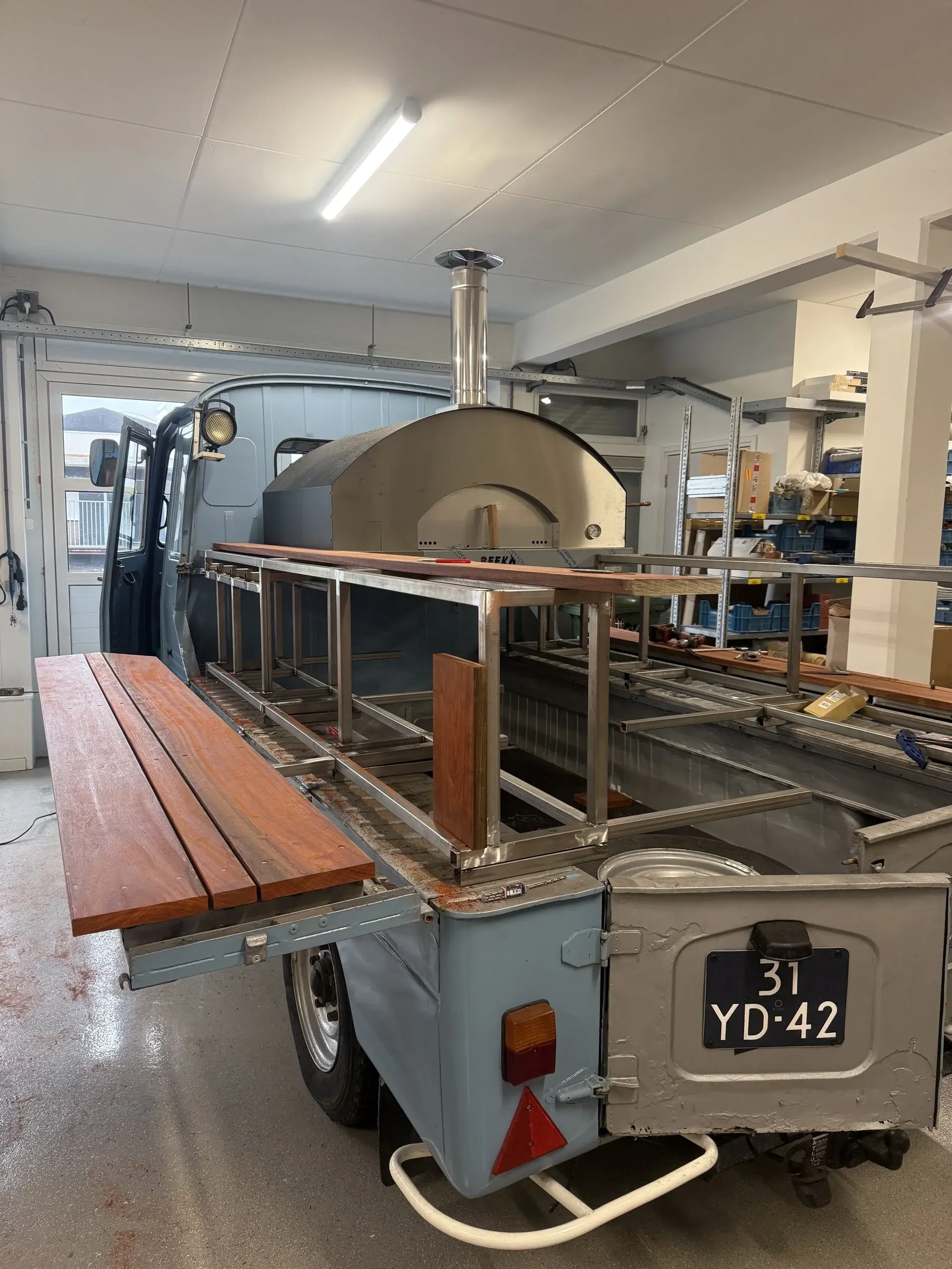De oude vlam in aanbouw met de hout gestookte pizzaoven op de open bak